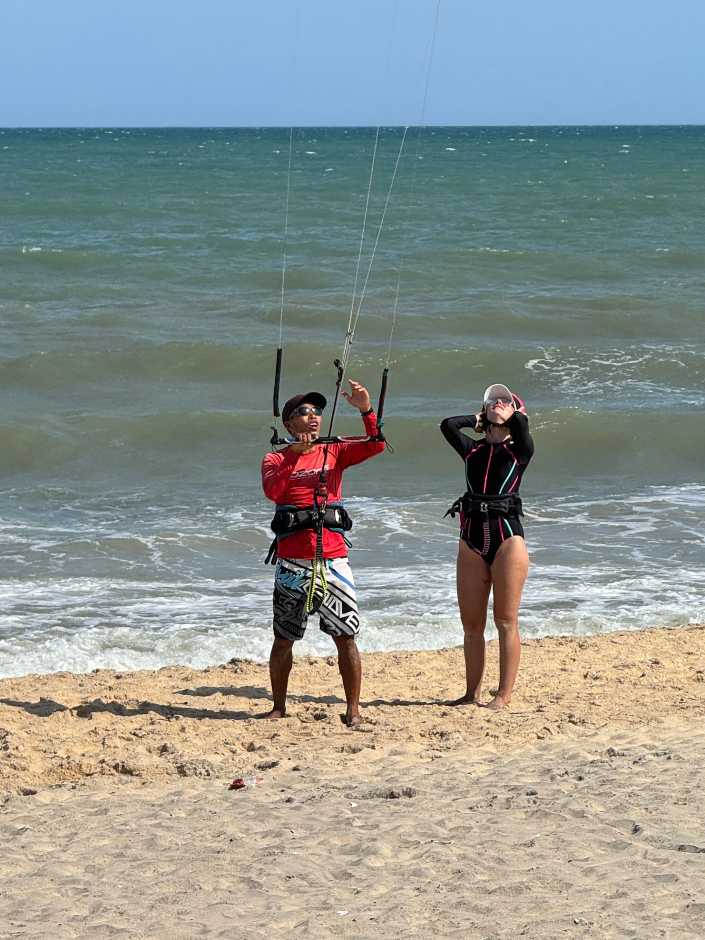 Lý coaching a student with the kite bar on Ham Tien beach