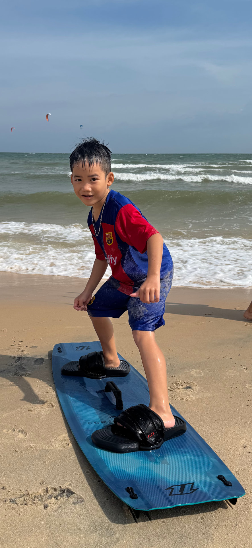 Young student balancing on a kiteboard on Ham Tien beach