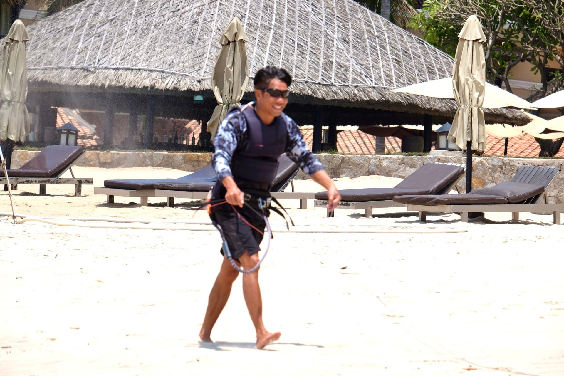 Lý walking on the beach with his harness before a session