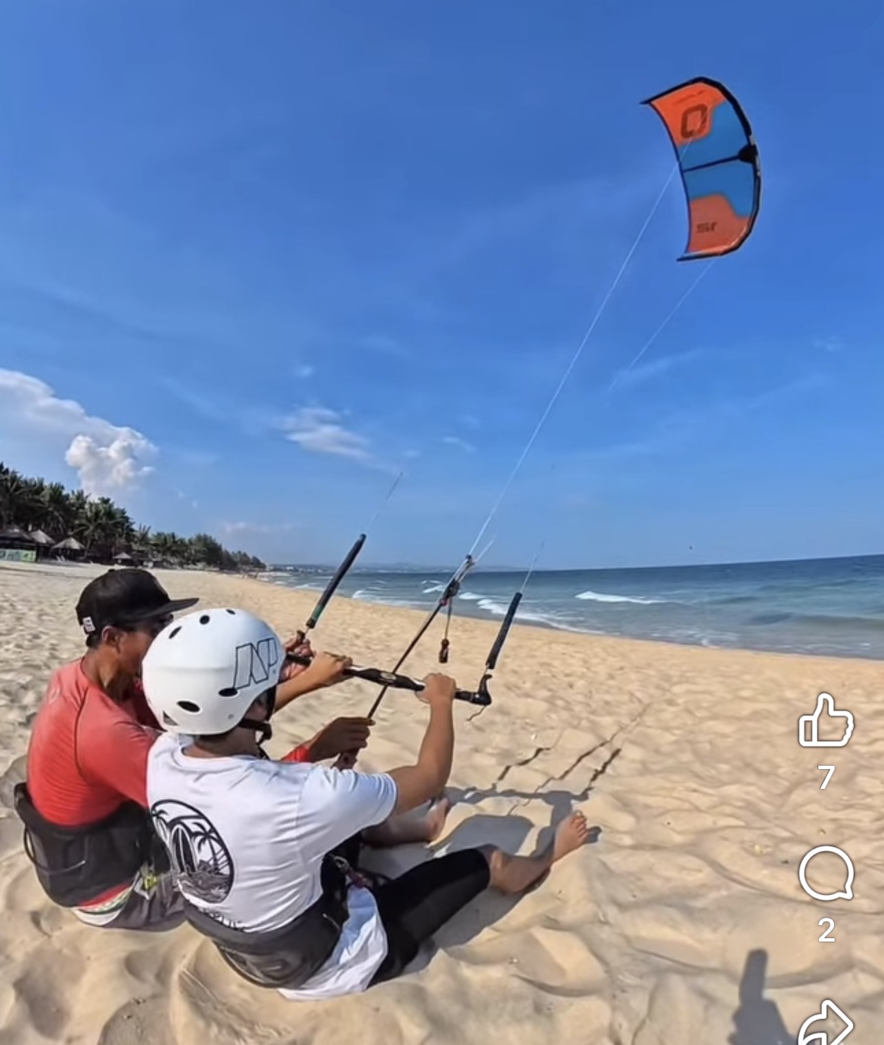 Instructor guiding a student flying a training kite on Ham Tien beach