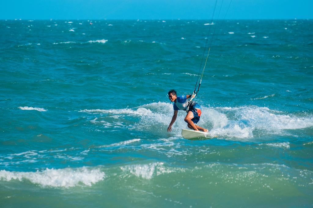 Lý kitesurfing on a wave at Ham Tien beach, Mui Ne